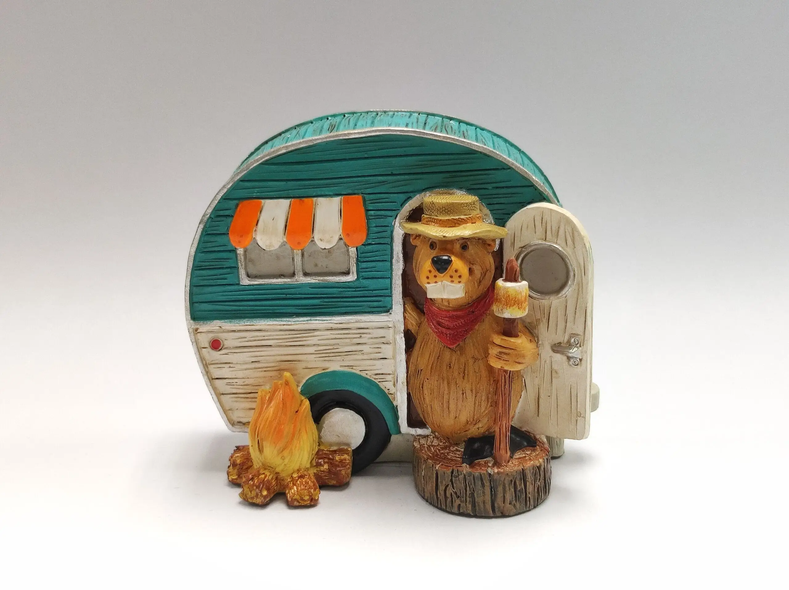 Bear figurine with camper and campfire.